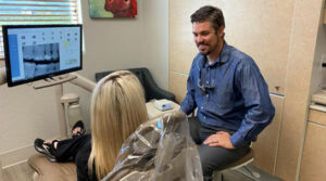 Dentists Dr. McArthur consults with a female patient about her treatment options